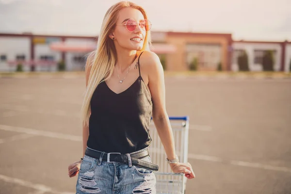 Alışveriş arabalı şık genç bir kadın. — Stok fotoğraf