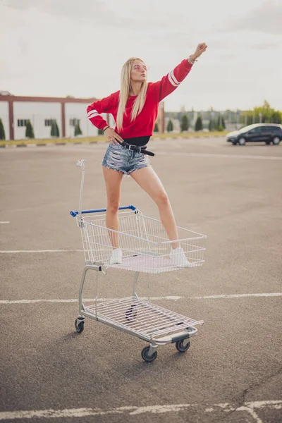 Confiante jovem hipster montando carrinho de compras — Fotografia de Stock