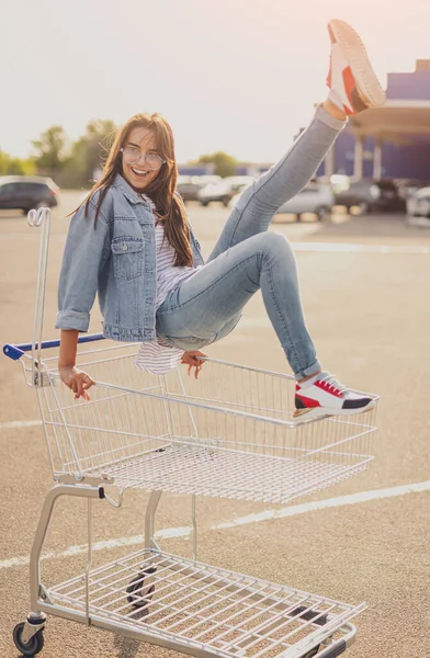 Joyeux jeune femme assise sur le panier — Photo