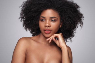 Temiz tenli düşünceli siyah kadın.