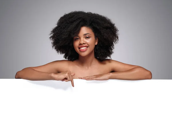Pozitív afro-amerikai modell, üres transzparensre mutatva — Stock Fotó