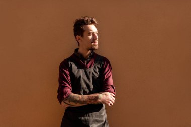 Siyah önlüklü ciddi bir erkek barmen.