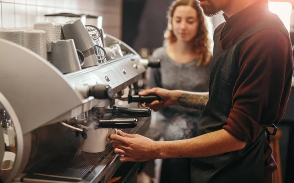 Barista con colega haciendo café en máquina de café — Foto de Stock