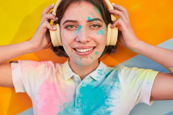 Mujer joven feliz con cara colorida escuchando música —  Fotos de Stock