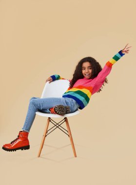 Mutlu etnik çocuk sandalyede eğleniyor