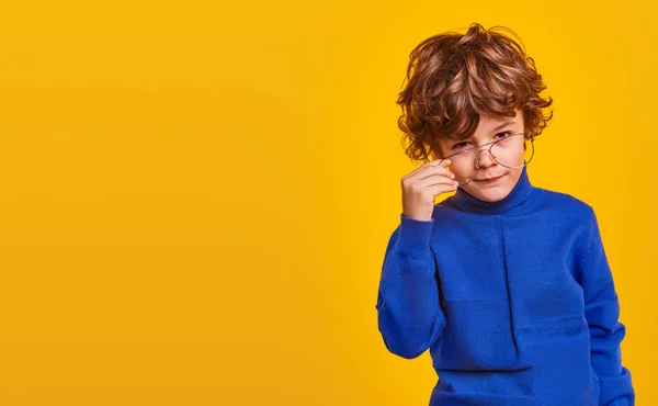 Nieuwsgierig kind in bril kijkend naar camera — Stockfoto