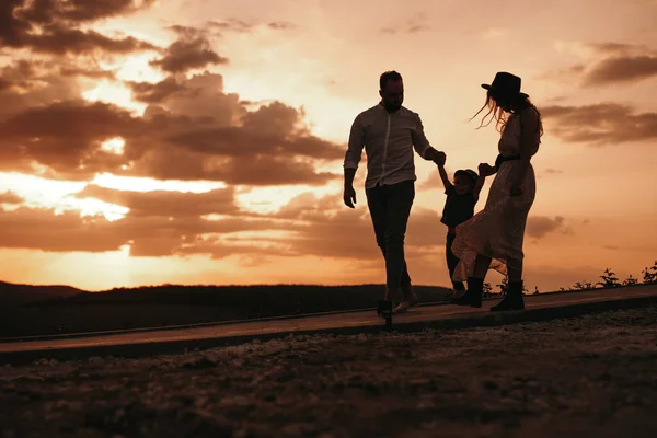 Padres cariñosos con niño caminando en el campo nocturno — Foto de Stock