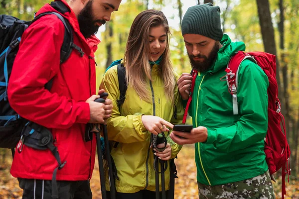 Jóvenes viajeros examinando mapa en el teléfono inteligente — Foto de Stock
