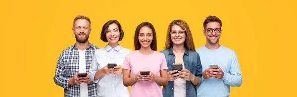 Vrolijke jongeren met smartphones in handen — Stockfoto