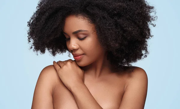 Femme noire enduisant crème sur l'épaule — Photo