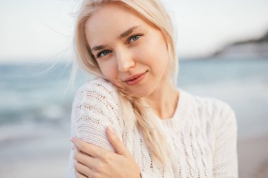 Kumsalda dinlenen hassas genç bir kadın.