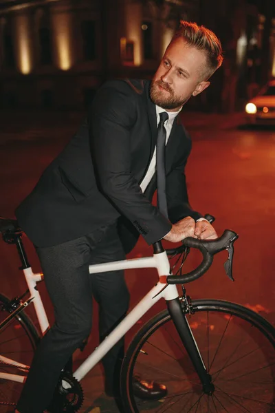 Barbudo hombre de negocios montar en bicicleta por la noche — Foto de Stock