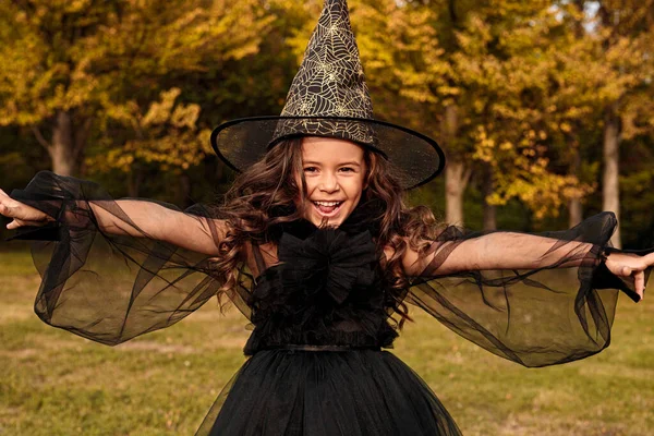 Menina bonito no traje de bruxa no fundo da natureza — Fotografia de Stock