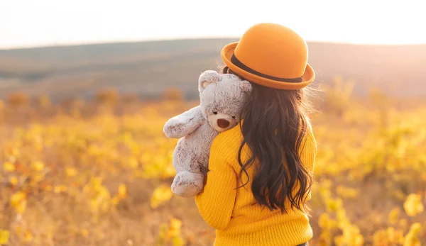 Самотня дівчинка з іграшкою в полі — стокове фото