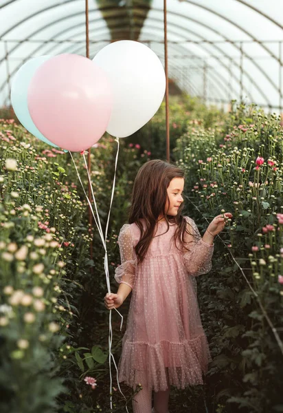 Criança com balões andando em estufa — Fotografia de Stock