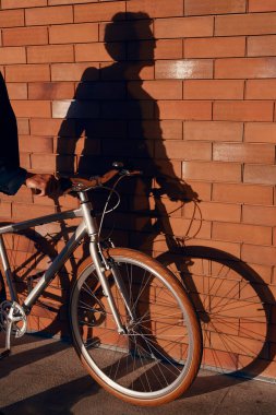 Mahsul adam bisikleti duvarın yakınına park ediyor.