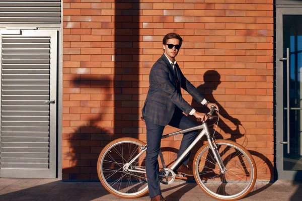 Selbstbewusster Geschäftsmann auf Fahrrad in der Nähe von Ziegelbau — Stockfoto