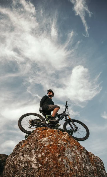 Ciclista di sesso maschile in cima alla roccia — Foto Stock