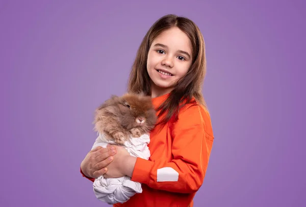 Adorable chica sonriendo y abrazando conejo — Foto de Stock