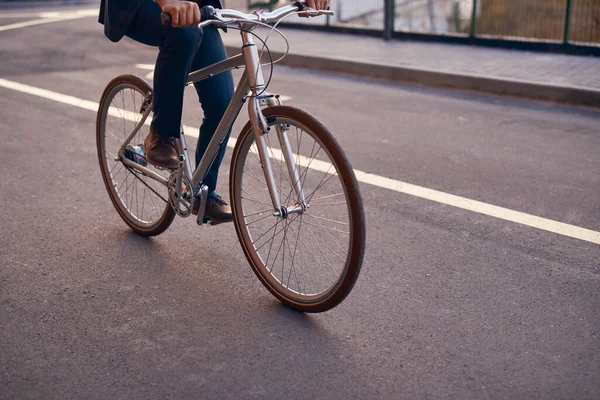 Crop man rijden fiets op de weg — Stockfoto