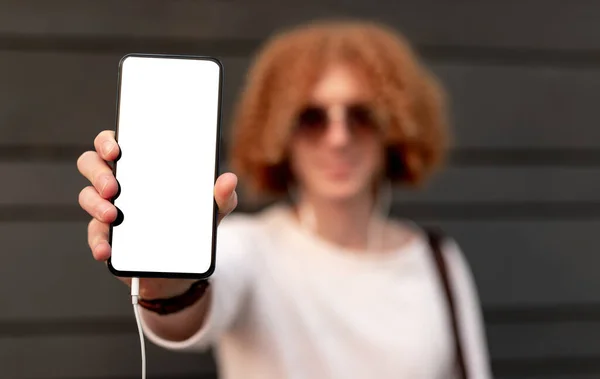 Homem desfocado mostrando smartphone com tela em branco — Fotografia de Stock