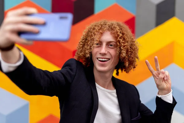 Macho hipster tomando selfie contra colorido pared — Foto de Stock