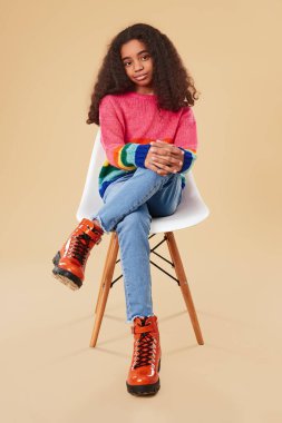 Şık siyah kız sandalyede oturuyor.