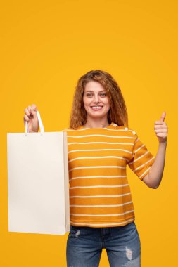 Mutlu bayan alışverişçi başparmağını kaldırıyor