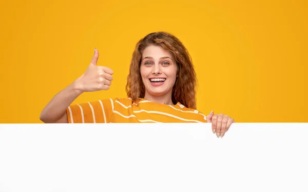 Mulher excitada aprovando cartaz em branco — Fotografia de Stock