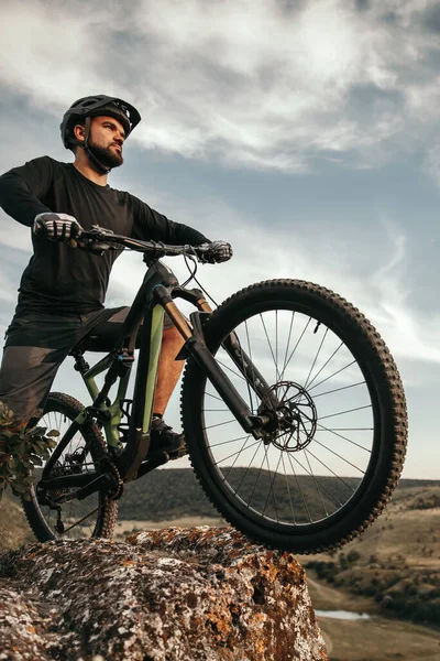 Бородатий велосипедист з велосипедом на скелі в природі — стокове фото