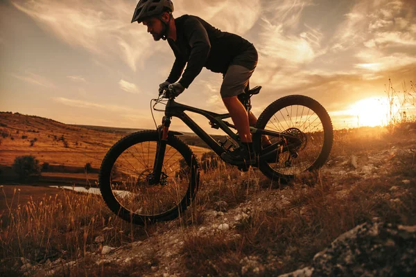 Homem ativo andar de bicicleta de montanha ao pôr do sol — Fotografia de Stock