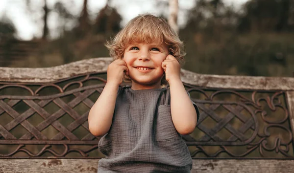 Cute child making face on bench