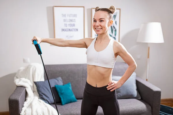 Cheerful woman exercising with resistance band at home — Stock Photo, Image