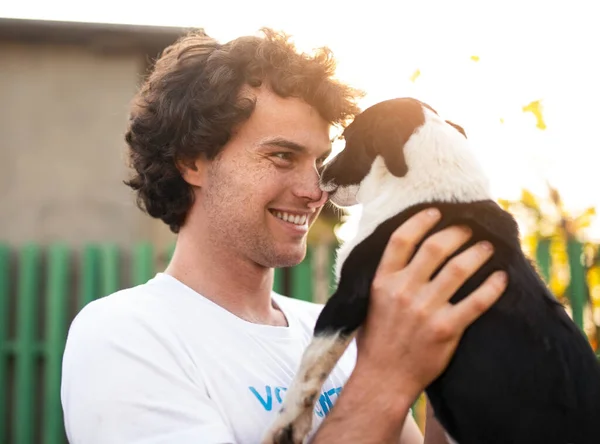 Happy volunteer playing with homeless dog — Stock Photo, Image