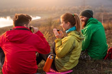 Gezginler kırsalda sıcak içecek içiyorlar.