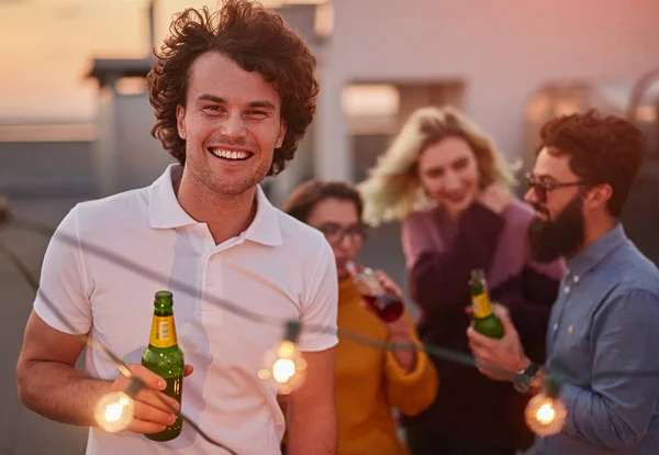 Uomo felice con birra durante la festa con gli amici — Foto Stock