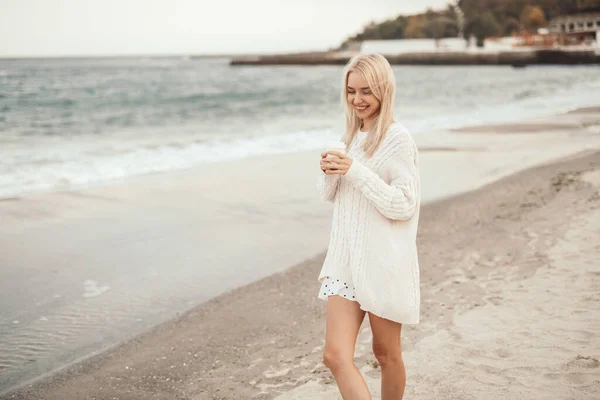 Mulher feliz com copo descansando perto do mar — Fotografia de Stock