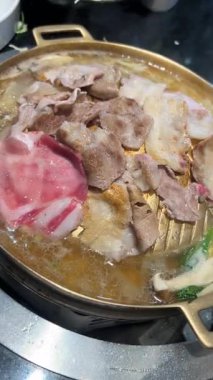 4K, Tayland BBBQ Mookata usulü, altın tepside domuz ve sığır eti ızgarası videosu. Lezzetli Asya sokak yemekleri, dumanlı ızgara et ve geleneksel Tayland yemeği deneyimi. Yemek temaları için mükemmel.