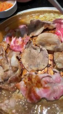 4K, Tayland BBBQ Mookata usulü, altın tepside domuz ve sığır eti ızgarası videosu. Lezzetli Asya sokak yemekleri, dumanlı ızgara et ve geleneksel Tayland yemeği deneyimi. Yemek temaları için mükemmel.