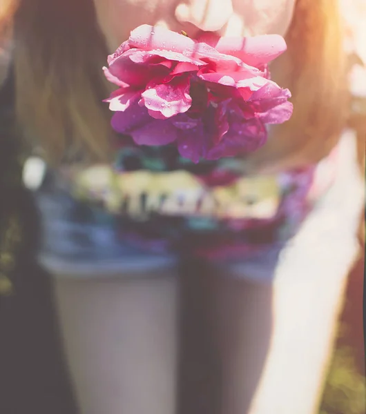 Menina Sentada Chão Shorts Segurando Uma Flor Rosa Seus Dentes — Fotografia de Stock