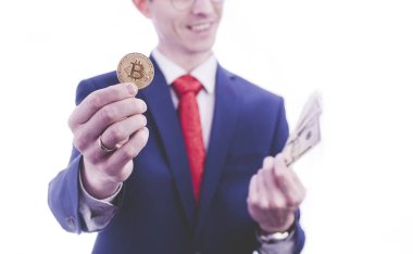İşadamı bitcoin ve para beyaz arka plan üzerinde tutan takım elbiseli