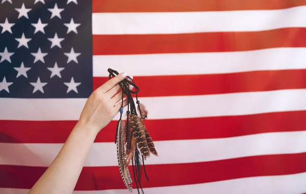 Feathers birds  for the hipsters in a woman\'s hand on the American flag background