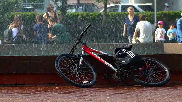 Yaz. ısı. Çeşme. bir çeşme arka planda Bisiklet ile çocuklar