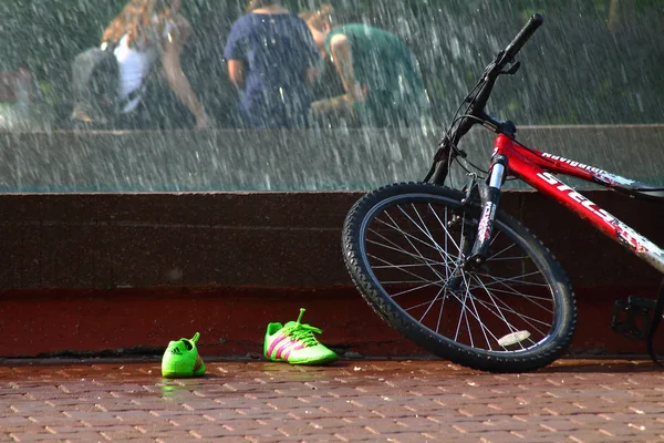 Yaz. ısı. Çeşme. bir çeşme arka planda Bisiklet ile çocuklar