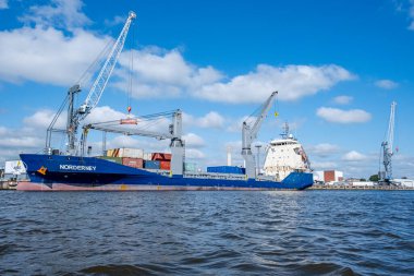 Emden, Lower Saxony Almanya 08 19 2025: Emden limanına demirlemiş konteyner gemisi Norderney 'in sudan görüntüsü