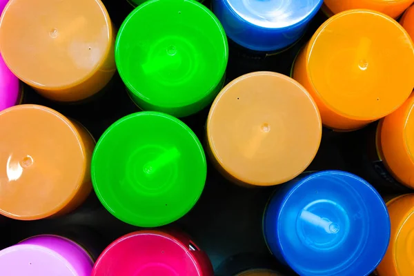 Multi-colored spray caps. Multicolored plastic garbage background. Bright round objects, top view