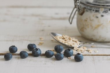 Yaban mersini, kaşık ile bütün yulaf ve kavanoz witj ev yapımı gece yulaf ezmesi ahşap tablo