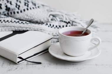 Kırmızı hibiscus çay, kitap ve sıcak örme battaniye fincan. Okuma kavramı. Çay molası evde