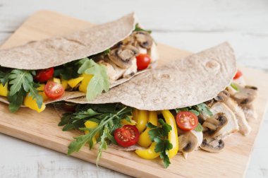 Tam buğday mantar, tavuk göğsü, sarı kırmızı biber, maydanoz, roka ve kırmızı kiraz domates ile tamamladı. Sağlıklı sandviç