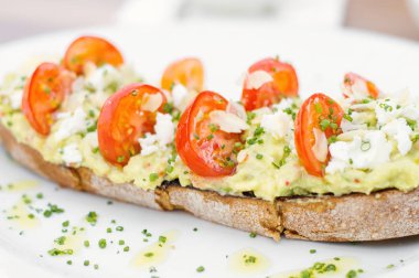 Kırmızı Kiraz domates ve beyaz peynir ile avokado tost. Sağlıklı kahvaltı yemek